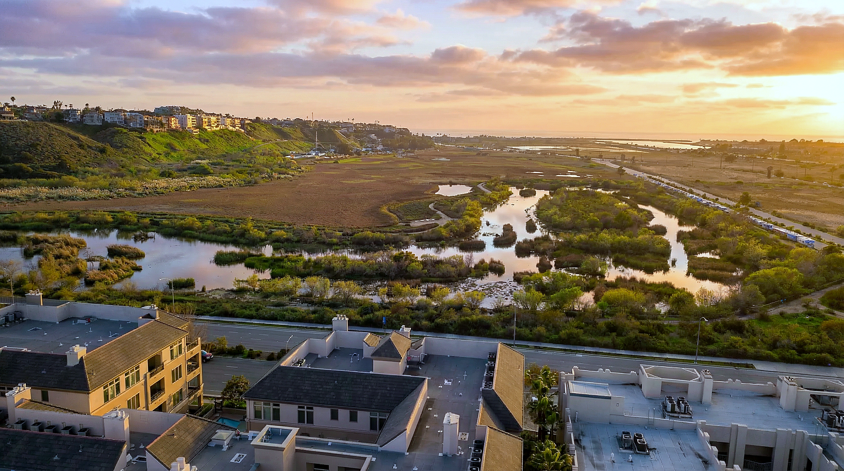 Ballona Creek wetlands with Playa Vista homes and Playa del Rey bluffs at sunset